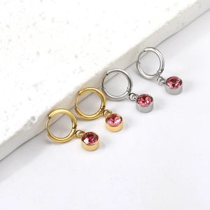 Boucles d'oreilles créoles dorées et argentées avec cristaux roses sur socle blanc