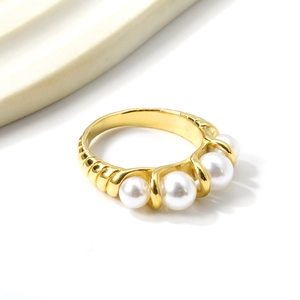 Elegant gold plated stainless steel ring featuring five pearls and textured details