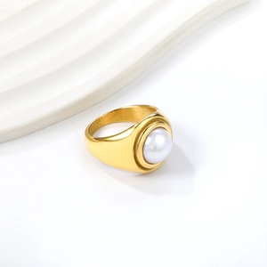 Detailed close-up of a large white pearl set on a wide 18K gold-plated stainless steel band