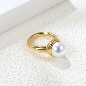 Detailed view of a round white pearl set on an 18K gold-plated stainless steel ring
