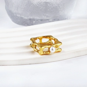Detail of 18K gold-plated irregular ring with a white pearl on a wave stand