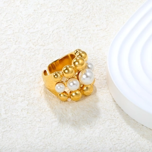 Macro shot of gold-plated multi-layer ring featuring white pearls and golden metal beads