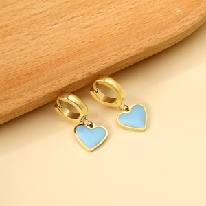 Boucles d'oreilles cœur dorées avec émail bleu ciel sur un plateau en bois naturel