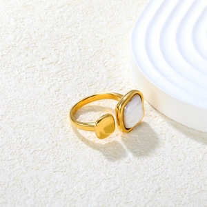 Detail of a minimalist gold ring with square white mother of pearl and geometric metal