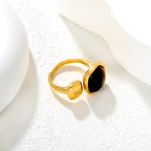 Detail of gold open ring featuring a square tiger eye stone on white artistic base