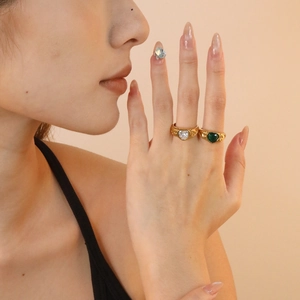 Detail of vintage 18K gold plated rings with emerald and zircon heart stones