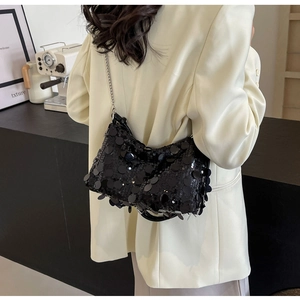 Detailed view of shimmering black sequins and elegant silver chain strap on evening bag