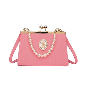 Sac à main vintage rose avec poignée en perles, relief camée et texture raffinée
