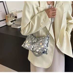 Detailed view of silver sequin handbag with metal chain strap and soft top handle
