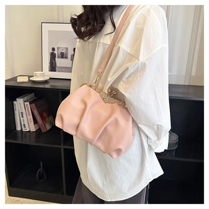 Detail of pink pleated cloud bag featuring sparkling rhinestone bow metal clasp closure
