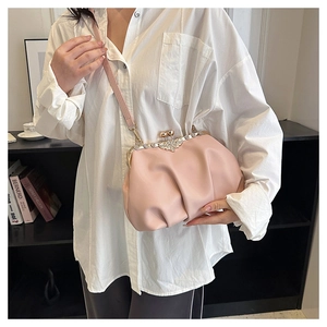 Detail of pink pleated cloud bag with a sparkling floral rhinestone clasp and slim strap