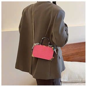 Detailed view of pink pleated handbag with silk scarf handle and gold chain strap