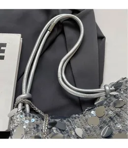 Close-up of silver sequin shoulder bag showing metal chain strap and reflective texture