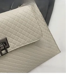 Detailansicht der gewebten cremefarbenen Ledertasche mit dunkelgrauem Metallverschluss