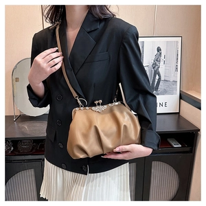 Detail view of brown pleated cloud bag with vintage diamond-encrusted metal clasp
