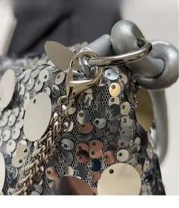 Close-up of sparkling silver sequins and durable metal hook detail on the handbag
