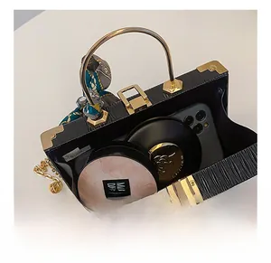 Detail shot of black embossed box bag interior showing capacity for phone and cosmetics