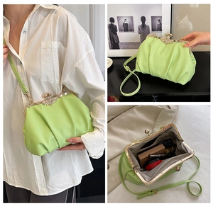 Detailed view of light green pleated handbag with gold crystal clasp and spacious interior