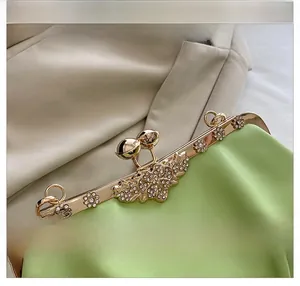 Detail of rose gold hardware with crystal flower clasp on light green leather shell bag