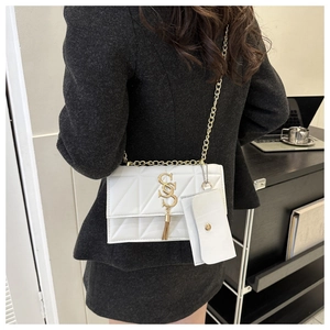 Détail du sac à bandoulière matelassé blanc avec chaîne dorée et mini pochette sur modèle