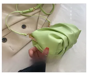 Side view of light green pleated cloud bag featuring gold metal frame and retro clasp
