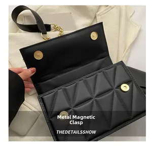 Détail des boucles magnétiques dorées sur sac bandoulière noir à motif matelassé
