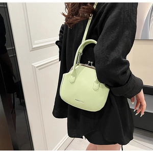Close-up of mint green shell bag with retro metal clasp and FASHION & BAG lettering