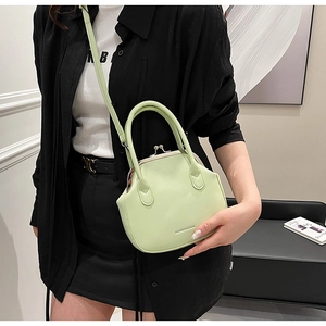 Detail of mint green PU leather bag featuring metal clasp and adjustable shoulder strap