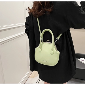 Detailed macro of mint green shell bag with retro metal clasp and leather texture