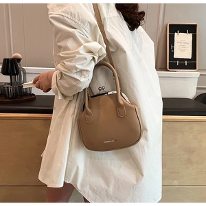 Detail of retro leather handbag with metal clip closure and fashion bag lettering