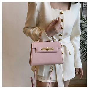 Detalle de bolso trapezoidal rosa Saffiano con cierre dorado y correa de cadena