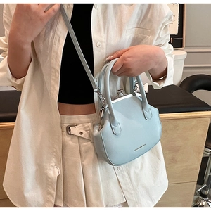 Close-up of light blue vintage kiss-lock bag with silver metal clasp and logo detail