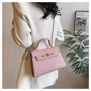 Bolso bandolera rosa con textura de palma, cierre dorado y detalle de cadena fina