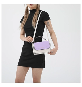 Detail of color-block flap handbag showing purple and beige PU leather with golden text