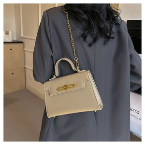 Detalle de bolso de cuero beige con grano de palma, cadena dorada y herrajes elegantes