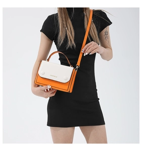Detail view of contrast color PU leather crossbody bag with golden hardware on a model