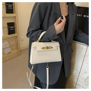 Detalle del bolso de cuero blanco crema con textura granulada y cierre dorado en modelo