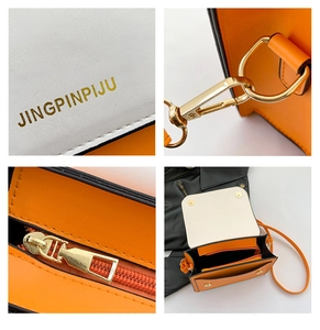 Detail view of contrast color handbag showing gold logo, zippers and inner compartment