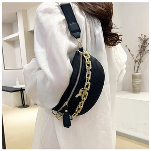 Détail du sac croissant tressé noir avec chaîne dorée et pendentif cheval élégant
