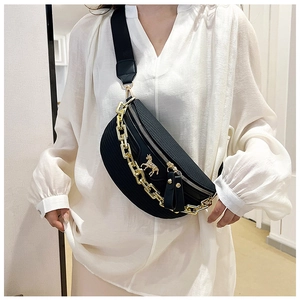 Détail du sac banane croissant noir avec chaîne dorée et emblème licorne porté par mannequin