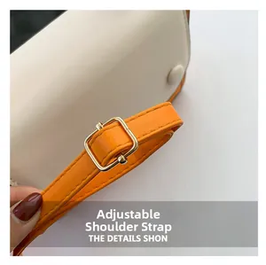 Detail of contrast stitching, cream faux leather and adjustable orange shoulder strap with buckle