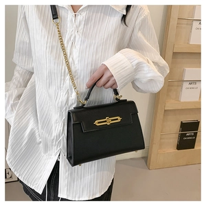 Bolso bandolera de piel negra estilo Kelly con cierre metálico dorado y detalle de cadena