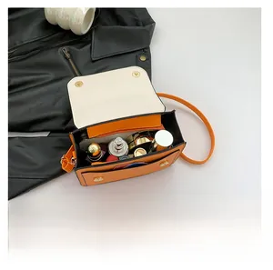 Interior storage capacity of the orange and cream contrast handbag with magnetic buckle