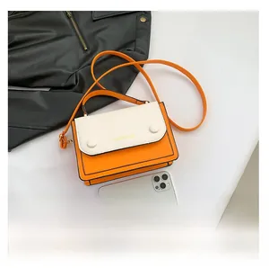 Detailed view of orange and cream contrast crossbody bag with leather texture and logo