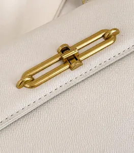 Detalle de cuero blanco con motivo litchi y elegante cierre de cadena metálica dorada