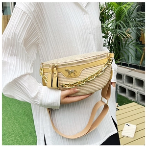 Détail macro d'un sac banane en paille avec boucle cheval dorée et décor de chaîne