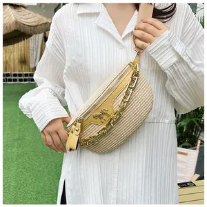 Détail du sac banane en paille kaki avec bordure en cuir jaune et emblème doré