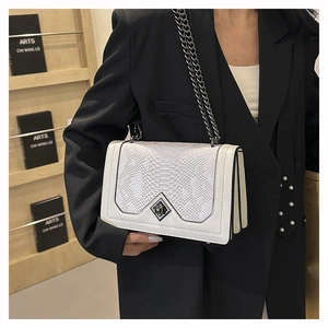 Detail showing white crocodile pattern leather handbag with metallic chain strap