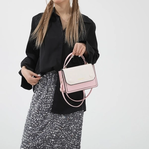 Fashionable color-block crossbody bag with pink and beige panels and golden logo detail