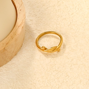 Detailed top view of a 18K gold plated twisted ring with a bead on a stone texture